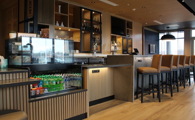 Cafe counter with a slatted front and lit back-bar shelving