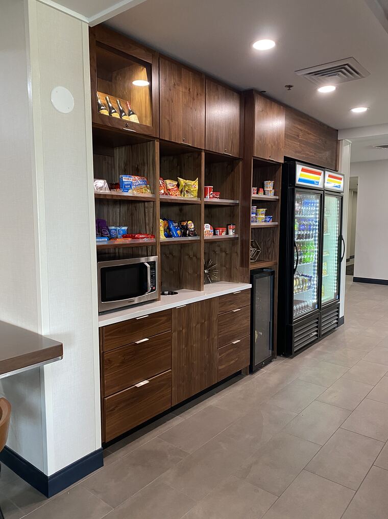 Commercial market with walnut cabinetry and lit open shelving