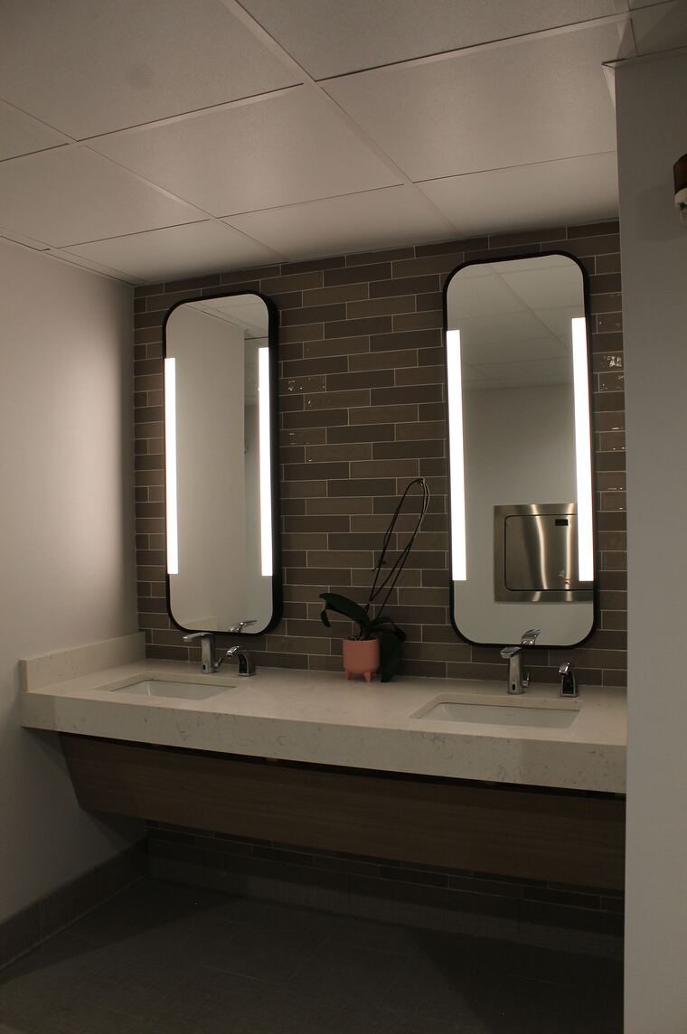 Restroom vanity with backlit mirrors