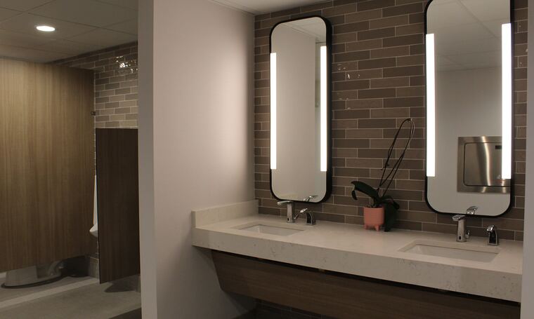 Restroom vanity with backlit mirrors