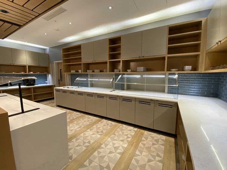 Commercial servery with an oak open-shelving wall