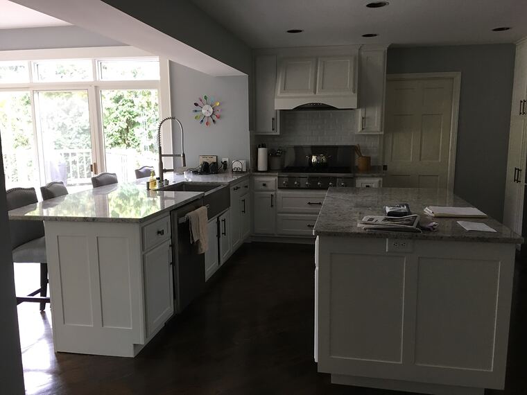 Custom white kitchen with an island and painted wood hood