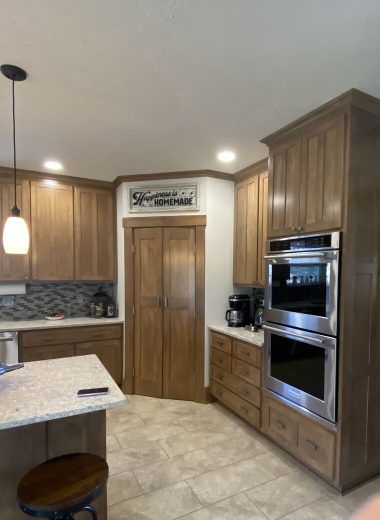 Maple kitchen with a full-height cabinet run and pantry doors