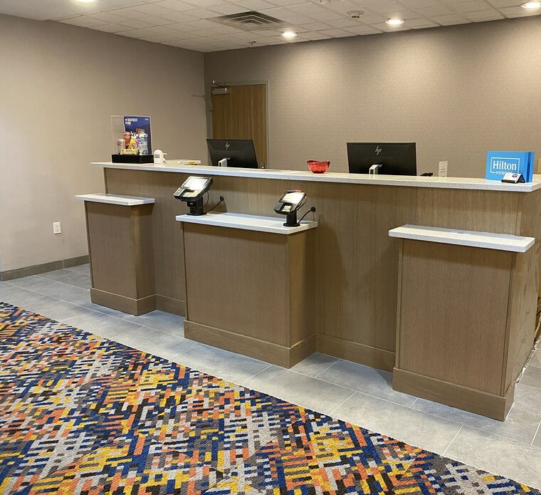 Hotel front desk in oak with a quartz transaction top