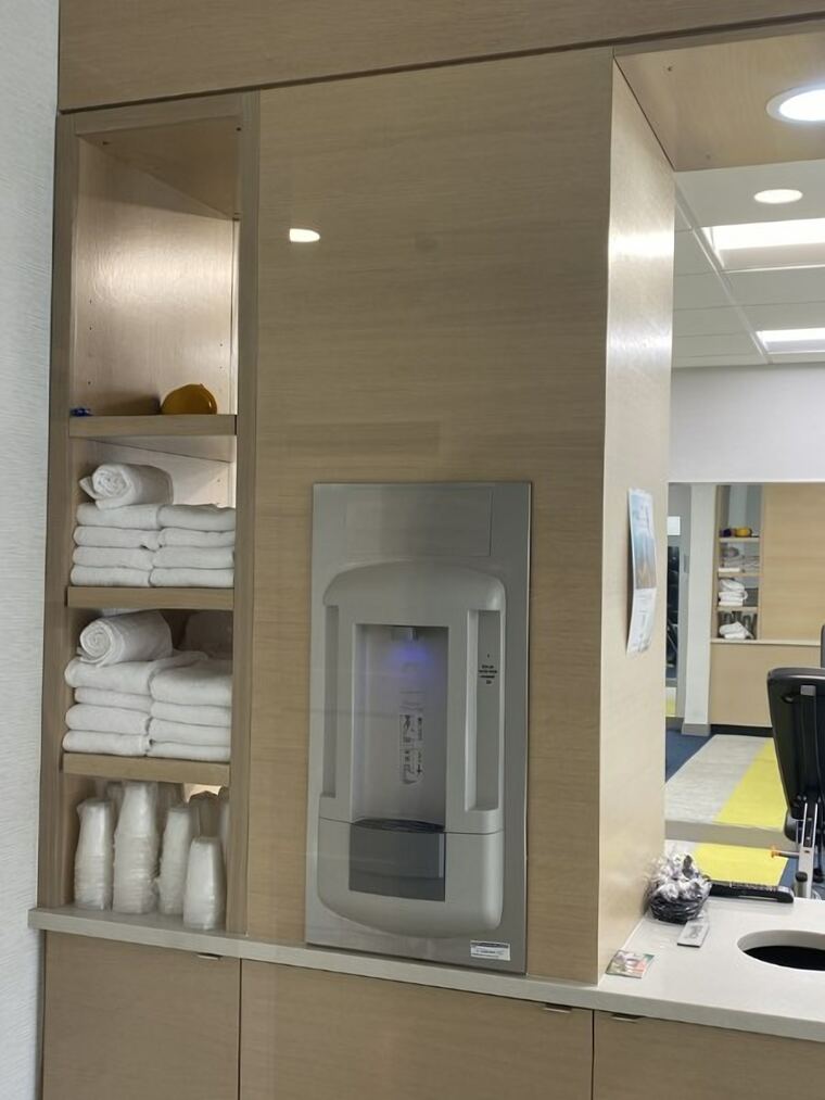 Hotel towel niche with open shelving in a light oak panel wall