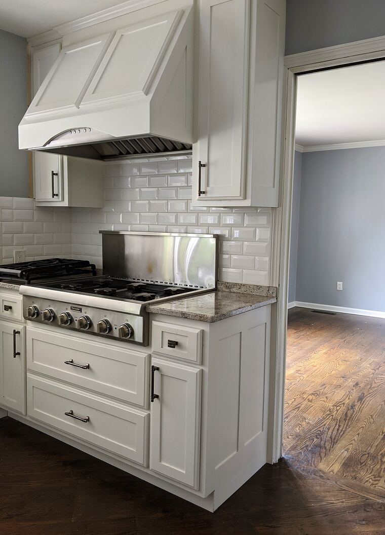 Kitchen with a custom painted wood hood and granite top