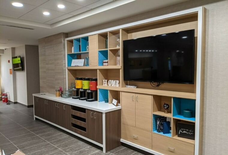 Lobby media wall with a coffee bar, television surround, and open cubbies
