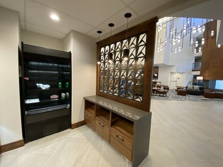 Lobby credenza in walnut with a decorative screen and pendant lighting