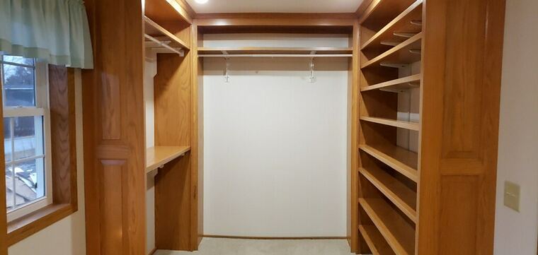 Oak walk-in closet with shelving towers and hanging rods