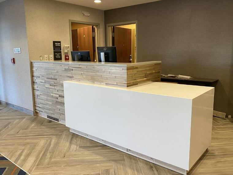 Reception desk with a quartz top and stacked-stone surround
