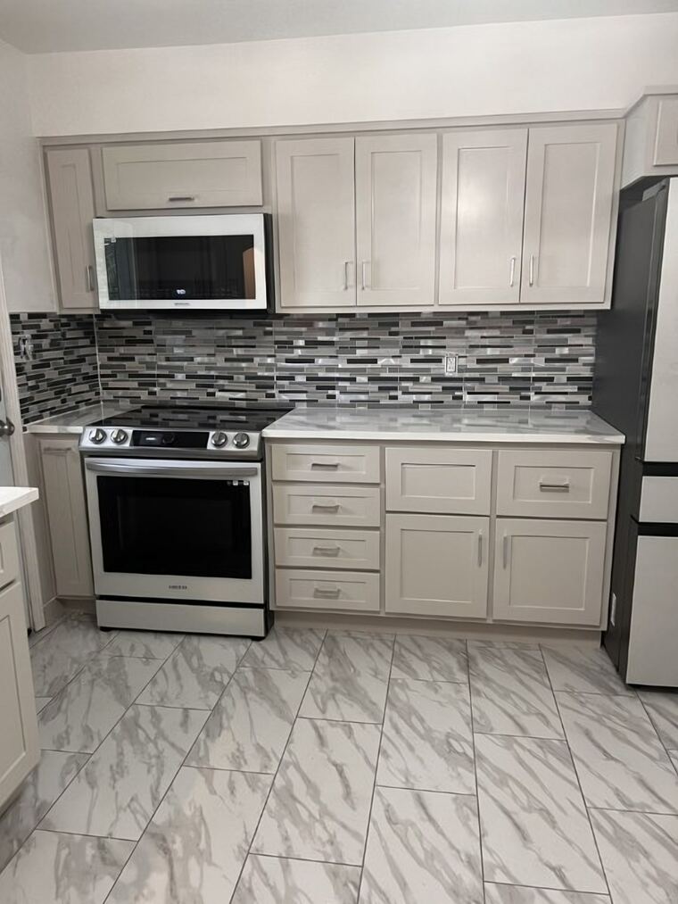 Painted shaker kitchen with upper cabinets and a drawer bank