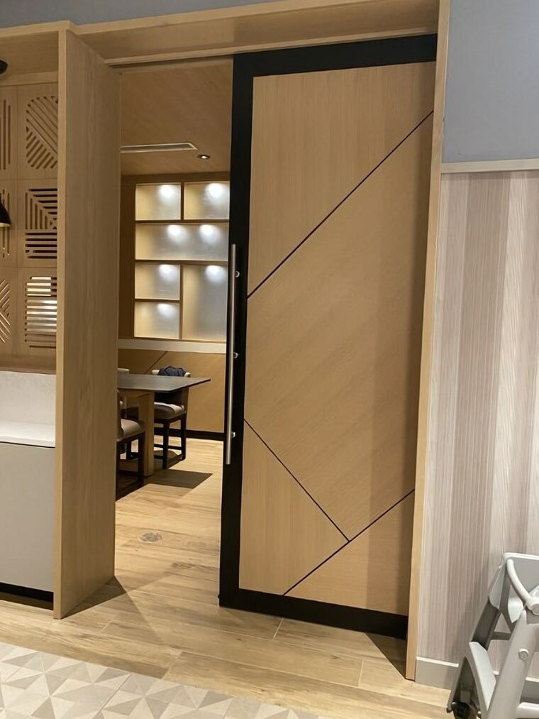 Sliding oak door with a black frame and inlay