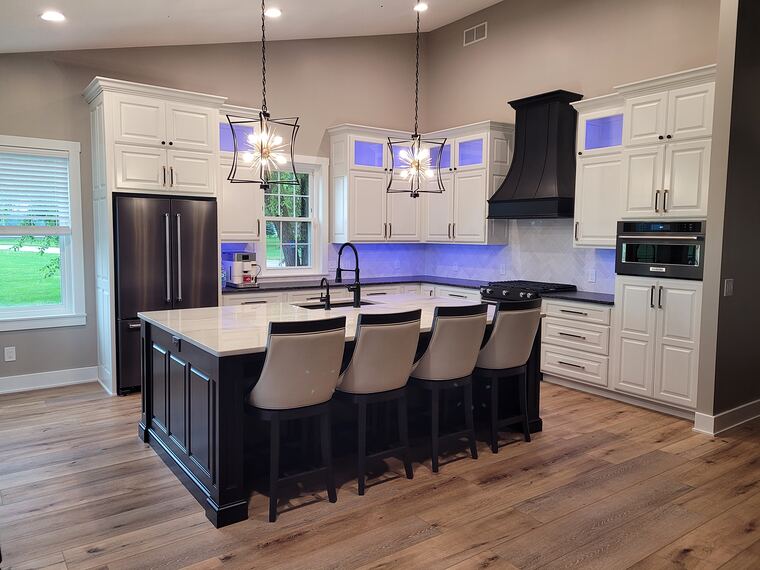 White kitchen with dark island and bar stools