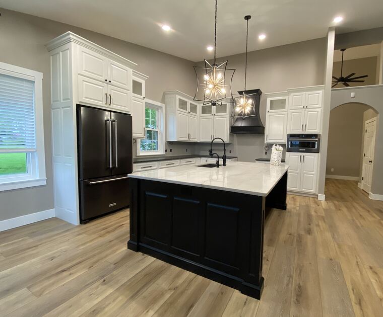 White kitchen with dark island and pendant lighting