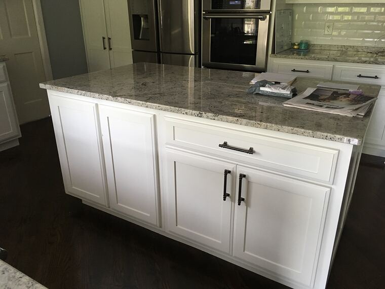 White kitchen island with a granite top